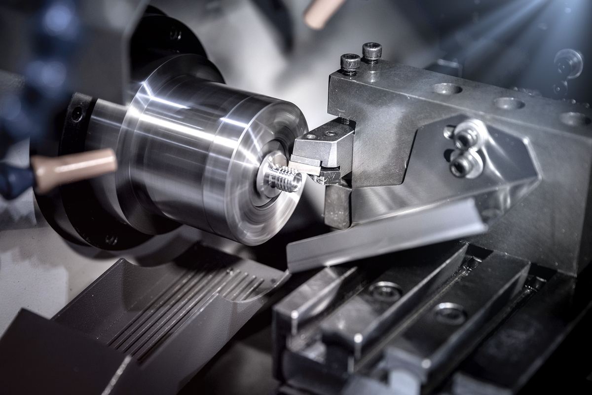 A cutting tool on a CNC lathe turning a steel part